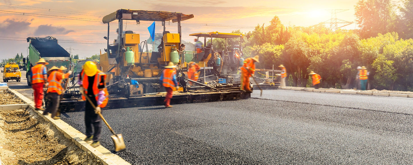 Construction site is laying new asphalt road pavement,road construction workers and road construction machinery scene.