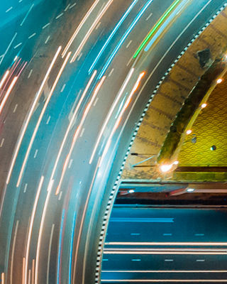 Aerial view of a busy highway interchange at night with streaks of car lights, symbolizing speed, connectivity, and innovation.